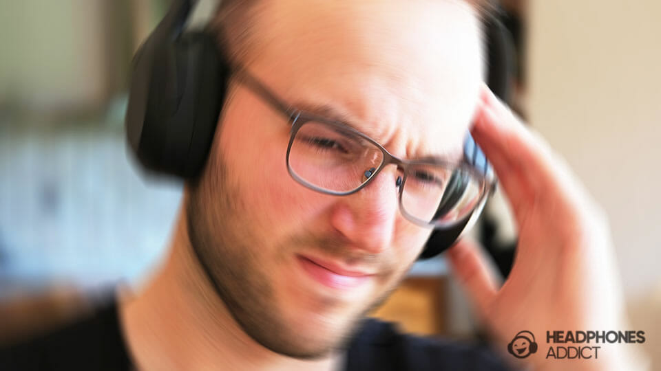 a man wearing headphones and touching his head